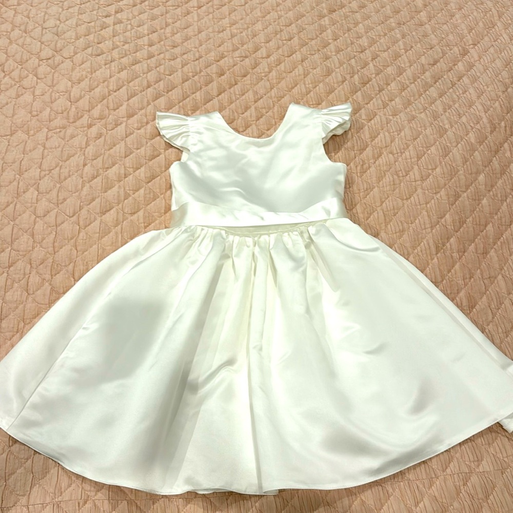 Beautiful ivory flower girl dress with bow and beading back detail.